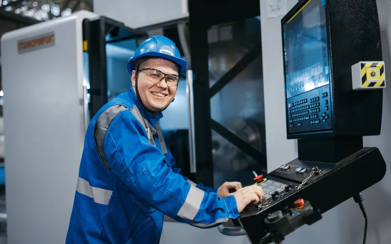 A machinist smiling at his CNC control